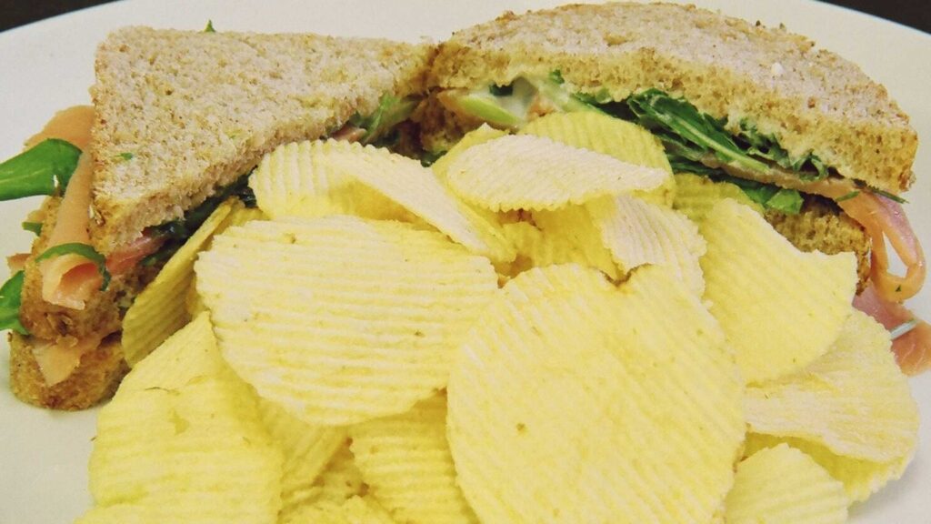 Pao integral com salmao defumado rucula ao molho de limao e ervas com batatas chips